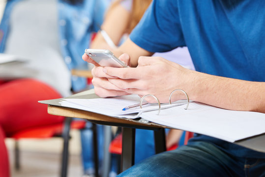 Schüler liest SMS auf dem Smartphone