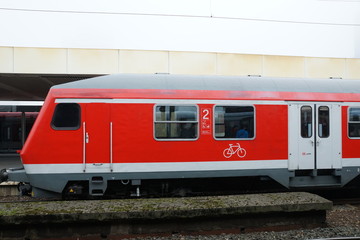 Naklejka premium Red Train On Tracks At Station 