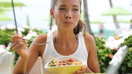Woman eating salad at restaurant outdoors in summer. 59.94 FPS.
