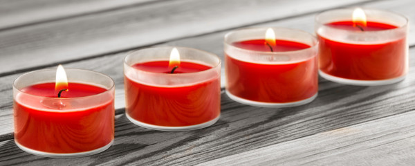 Four candles and wooden background