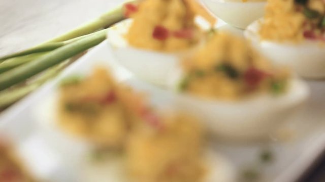 Deviled eggs garnished with green onions and bacon