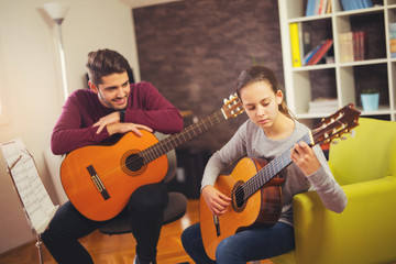 Guitar teacher teaching the little girl