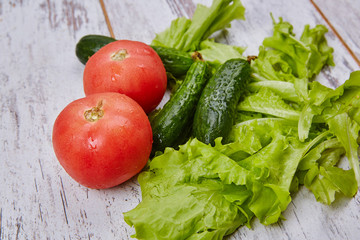 Salad, tomato and cucumber on rustic table