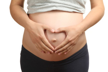Pregnant Woman holding her hands in a heart shape on her stomach. Pregnant Belly with fingers Heart symbol. Maternity concept. 