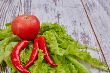 Salad, tomato and chile pepper on rustic table