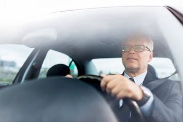 happy senior businessman driving car