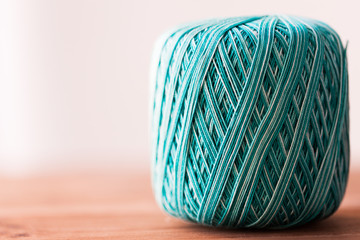 ball of turquoise cotton yarn on wood