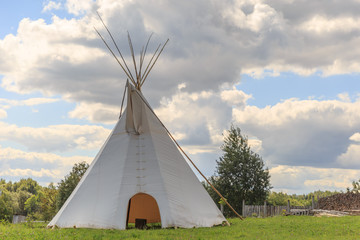 Wigwam on the field over the blue sky