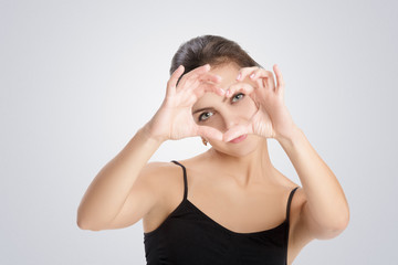 woman making heart of fingers