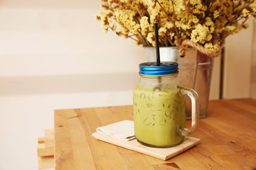 Ice green tea frappe glass on wood table.