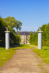 Wide road between columns leading to old medieval castle in distance