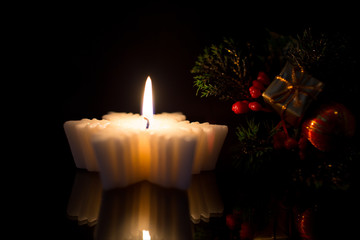 The branch of a Christmas tree with gifts, toys and candle