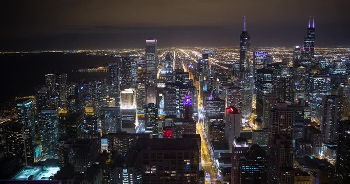 Chicago, Illinois, USA - view from John Hancock Center of City with Willis Tower (formerly Sears Tower), Tribune Tower and NBC Tower facing south at night - Timelapse with zoom out 