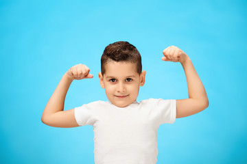 Beauty smiling sport child boy showing his biceps