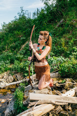 Young beautiful amazon girl hunting in the forest