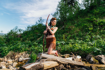 Young beautiful amazon girl hunting in the forest