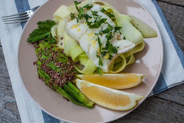 Cod fish with steamed zucchini pasta, avocado, flax seeds, lemon and spices. Love for a healthy raw food concept