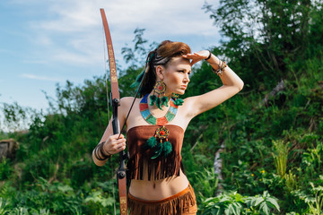 Young beautiful amazon girl hunting in the forest