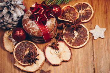Christmas still life with ginger honey biscuits, ornaments, pine, wreaths chocolate candy on a wooden background