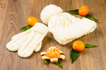 white knitting cap, mittens and tangerines