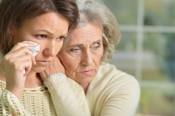 Sad senior and young women