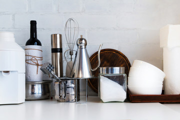 Kitchen interior - table with kitchen utensils ready for cooking against white brick wall. Selective focus. Copy space.