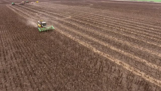Aerial shot of sunflower harvesting by using a modern combine harvester. 4K