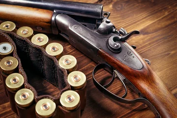 Schilderijen op glas Shotgun with shells on wooden background © zorandim75