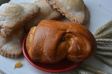 appetizing rosy cakes, raisins and wheat ears on a wooden background, food, dessert