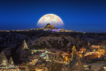 Full moon rising above Uchisar castle in Cappadocia, Turkey