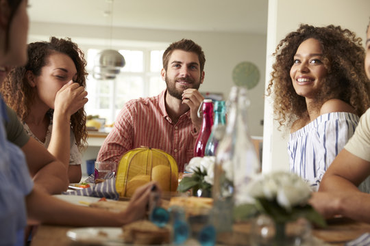 Young adult friends sitting at a table for lunch, close up