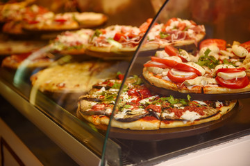 True italian pizza in the showcase of pizzeria in Florence, Italy. Food background.