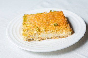 close-up of Arabic dessert Kunafa on a white background