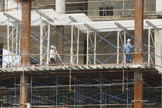 worker making level on steel column