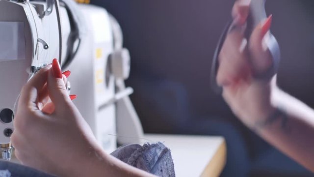 Woman Cut Thread near Sewing Machine