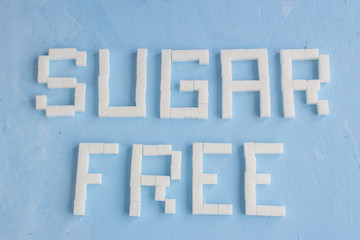 word is written from sugar cubes on blue background, sugar free