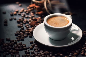 Fototapeten Fresh tasty espresso cup of hot coffee with coffee beans on dark © nerudol