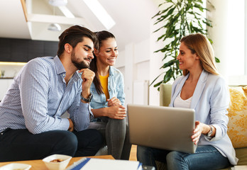 Female Real Estate agent offer home ownership and life insurance to young couple.