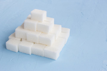 Pyramid from sugar cubes on a blue background