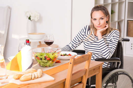 Women on wheelchair sitting at the table.