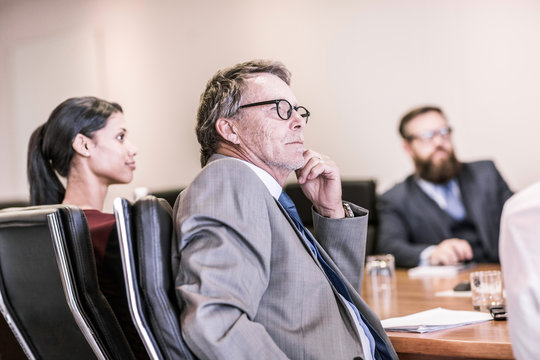 Businessmen and woman in board team meeting