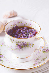 Beautiful cup of tea with flowers vertical