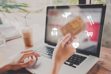 business hand typing on a laptop keyboard with credit card and online payment homepage on the...