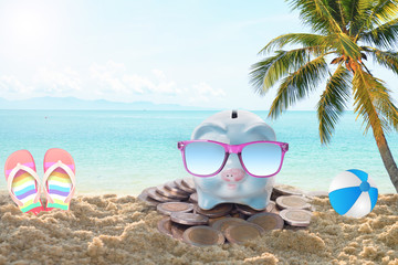 Fototapeta na wymiar travel piggy bank with sunglasses relax on the beach holiday. concept saving money for travel in holiday