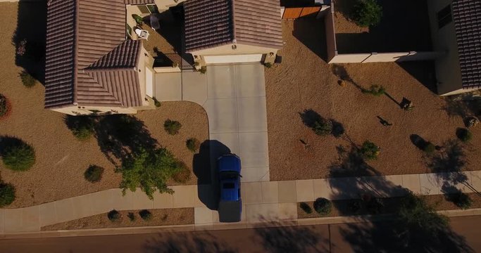 A unique aerial view of a truck pulling out of a typical Arizona neighborhood residence. Phoenix suburb.  	