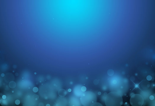 Dark blue sparkles below glitter rays lights bokeh abstract background/texture.