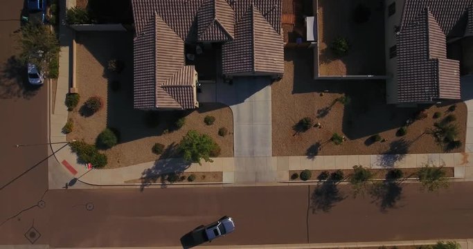 A unique aerial view of a truck pulling into the garage of a typical Arizona neighborhood home. Phoenix suburb.  	