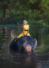 Woman and her elephant at the lake