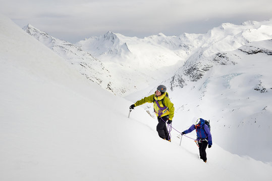 Mountaineers ascending snow-covered mountain, Saas Fee, Switzerland