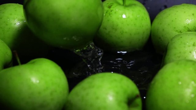 Green apple falling in water super slow motion shot
